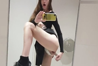 Милашка с хорошей фигурой мастурбирует в публичном туалете